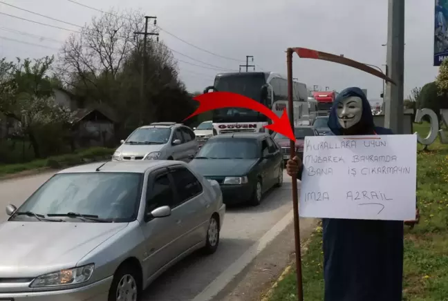 Bir elinde tırpan bir elinde pankartla trafiğe çıkıp sürücüleri uyardı